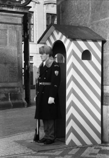 Membre de la Garde du Château de Prague (Hradní stráž) en uniforme,  devant une guérite à rayures.