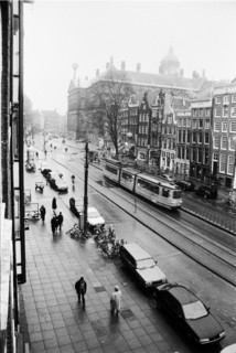 Vue plongeante sur l'avenue Nieuwezijds Voorburgwal bordée de bâtiments, avec un tramway, des