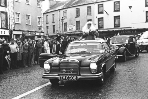 St Patrick's Day parade: a car drives down the street in front of spectators. Swinford, County