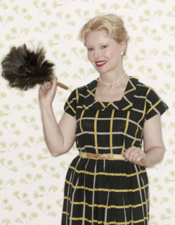 Woman holding a feather duster.