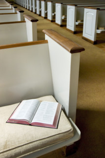 Interior of a church with Bible on a pew.