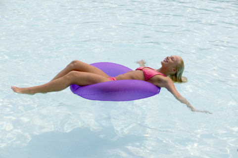 Woman floating in a swimming pool.