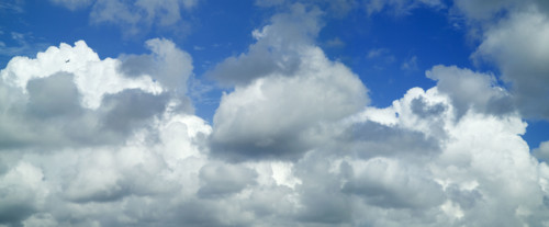 Puffy white clouds against a blue sky.