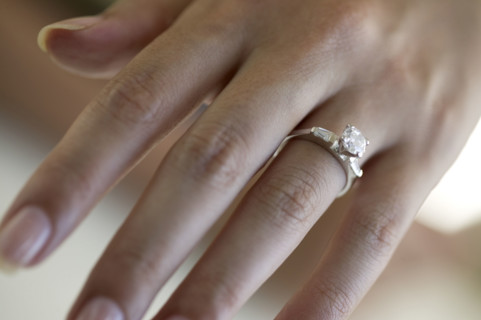 Woman's hand wearing an engagement ring.
