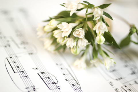 Still life of flowers and sheet music.