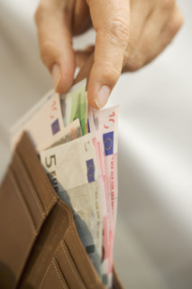 Man removing Euro bills from his wallet.