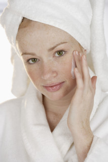 Woman applying face cream.