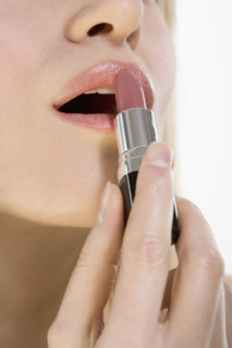 Closeup of lips with lipstick tube.