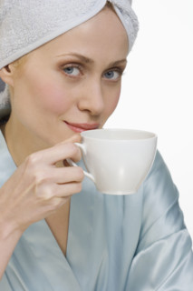 Woman in bathrobe with coffee cup.