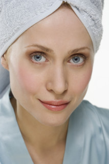 Smiling woman with towel on head.