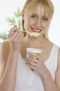 Woman eating cup of yogurt.