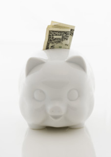 Piggy bank with dollar bill.