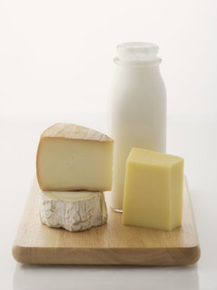 Cheese and milk on cutting board.