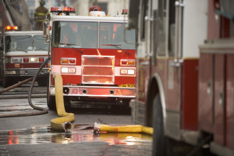 Firetrucks parked with hoses.