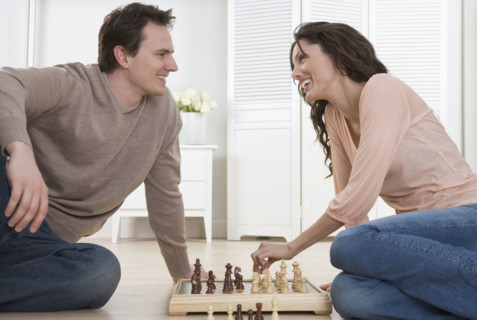 Smiling couple playing chess.