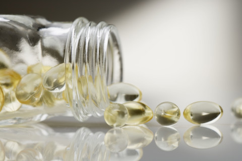 Gelcaps spilling out of glass bottle.