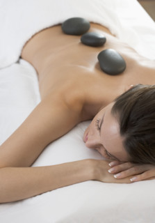 Woman on massage table with stones.