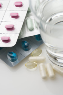 Many pills in packages with water.