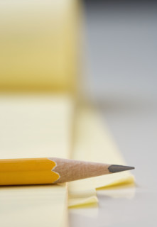 Sharpened pencil on pad of paper.