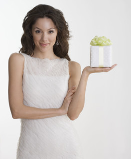 Woman in formal dress holding gift.