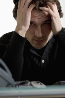 Closeup of upset man at desk.