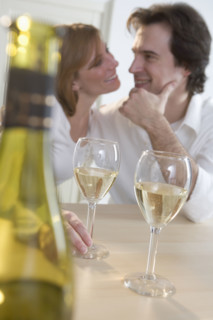 Couple at table with white wine.