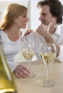 Laughing couple with white wine.