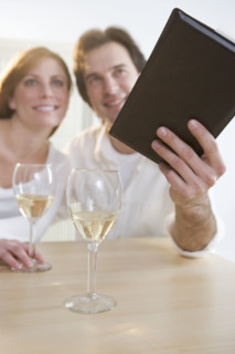 Couple with wine paying their bill.