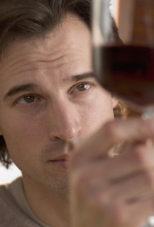 Closeup of man looking at wine.