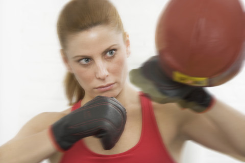 Female boxer hitting punching bag.