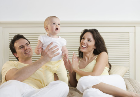 Proud couple lying down with infant.