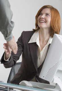 Businesswoman shaking hands with colleague.