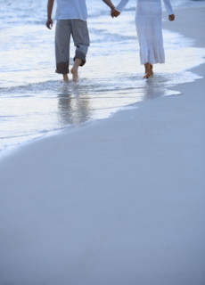 Couple walking along a beach.