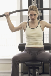 Woman working with resistance machine.