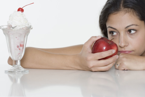 Woman with apple wanting ice cream sundae.