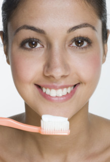 Smiling woman with toothbrush.