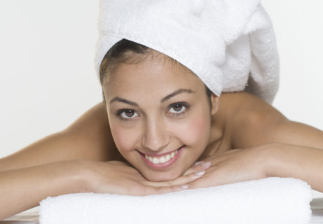 Smiling woman with towel on head.