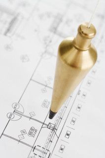 Plumb bob above blueprints.