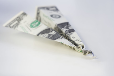 Still life of airplane made from dollar bill.