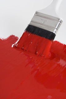 Still life of paint brush with red paint.