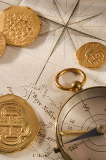 Still life of pieces of gold map and compass.