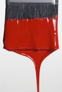 Still life of paint brush with red paint.