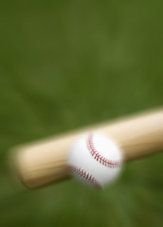 Closeup of bat hitting baseball.