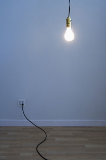 Bare light bulb in empty room.