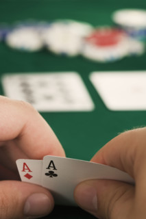 Hand holding two aces.