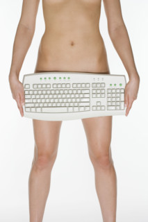 Nude female holding computer keyboard.
