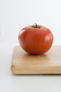 Fresh tomato on cutting board.