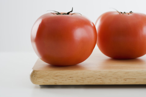 Tomatoes on cutting board.