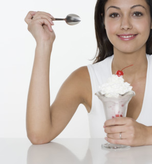 Smiling woman with ice cream sundae.