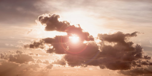 Sun peeking through dark cloud.